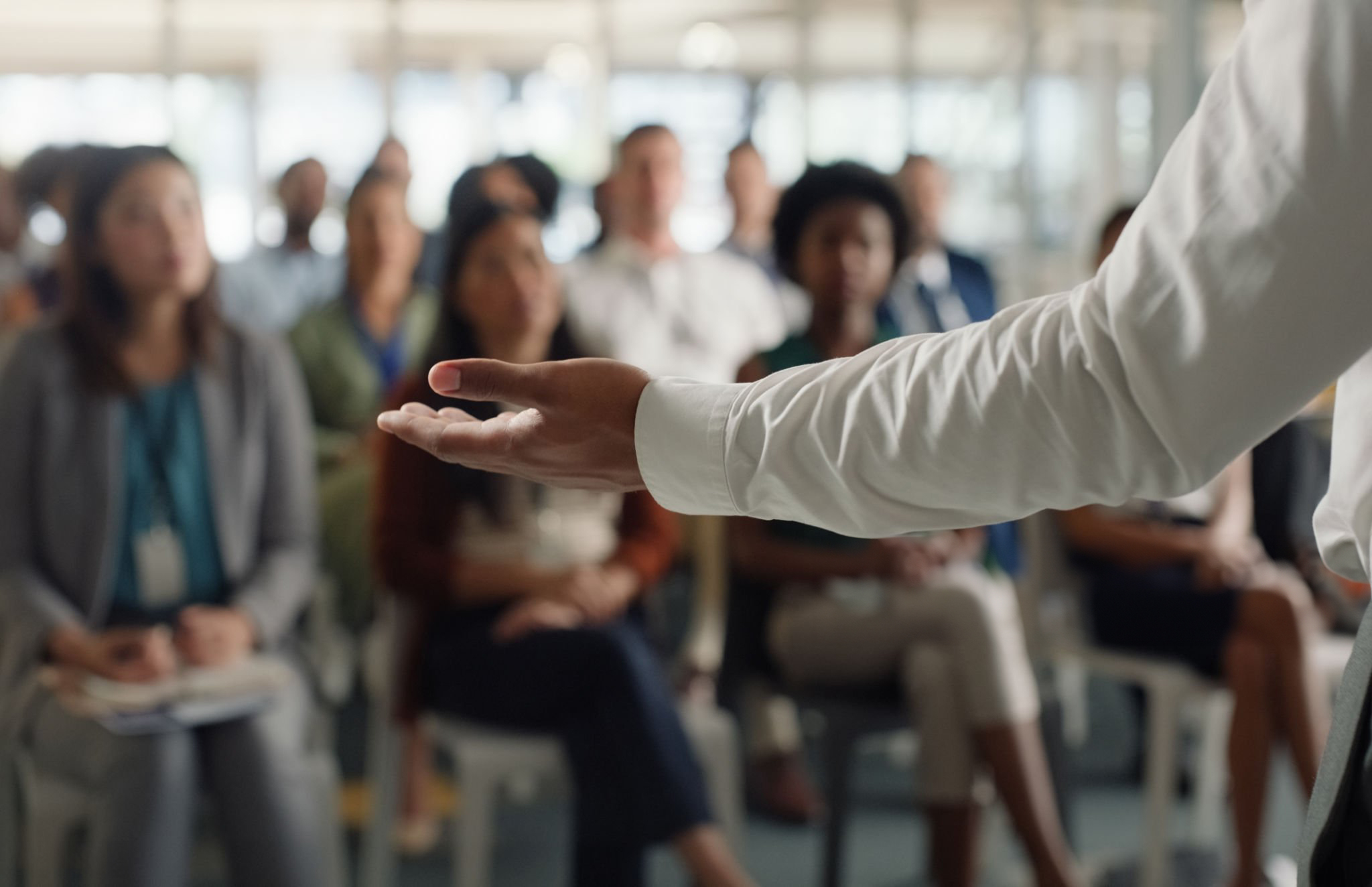 main d'un formateur devant une audience écoutant une formation en neurosciences