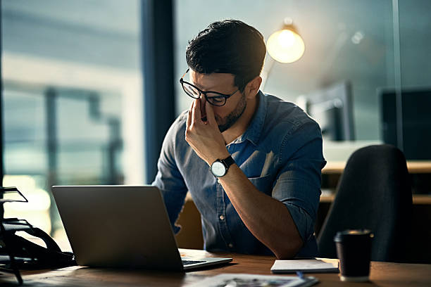 homme mettant la tête dans sa main en signe de fatigue et de stress